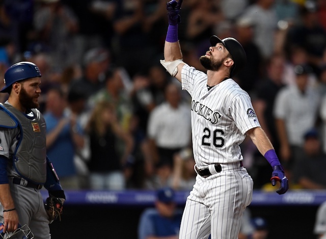 Los Angeles Dodgers catcher Russell Martin looks on as Colorado Rockies left fielder celebrates a home run at Coors Field