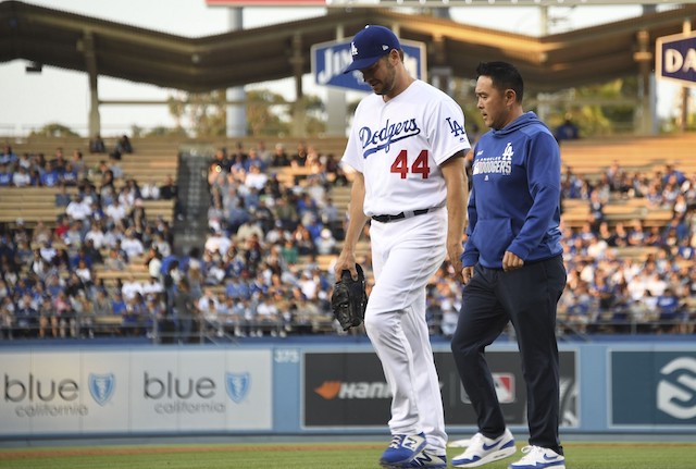 Starting pitcher Rich Hill walks off the field with a Los Angeles Dodgers trainer