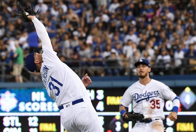 Los Angeles Dodgers right fielder Cody Bellinger watches Joc Pederson make a catch at first base