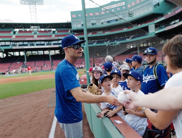 Los Angeles Dodgers relief pitcher Joe Kelly signs autographs for fans prior to a game against the Boston Red Sox at Fenway Park