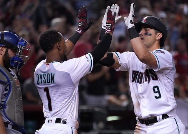 Los Angeles Dodgers catcher Russell Martin looks on as Arizona Diamondbacks teammates Jarrod Dyson and Josh Rojas celebrate after a home run