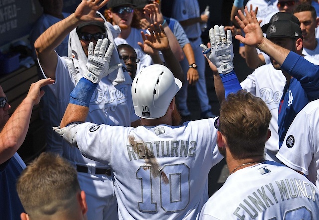 Los Angeles Dodgers teammates Max Muncy and Justin Turner are congratulated in the dugout