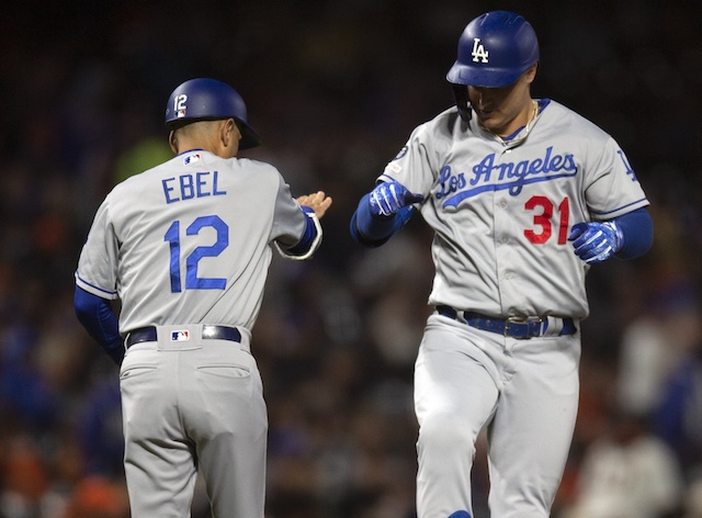 Los Angeles Dodgers third base coach Dino Ebel and Joc Pederson celebrate after a home run