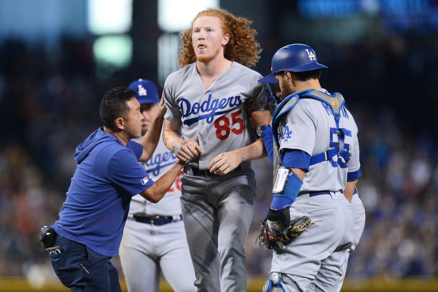 Los Angeles Dodgers pitcher Dustin May is helped to his feet after being hit by a line drive