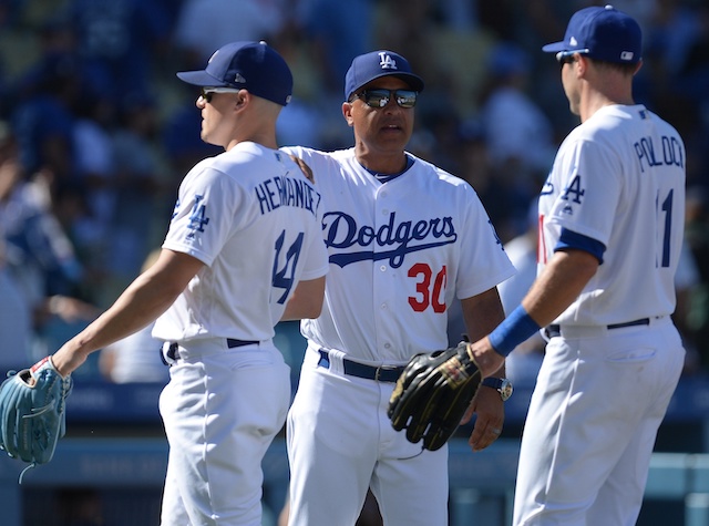 Los Angeles Dodgers manager Dave Roberts celebrates with Kiké Hernandez and A.J. Pollock after a win