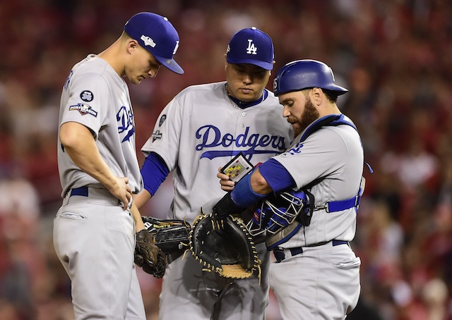 Los Angeles Dodgers teammates Russell Martin, Hyun-Jin Ryu and Corey Seager go over signs during a mound visit