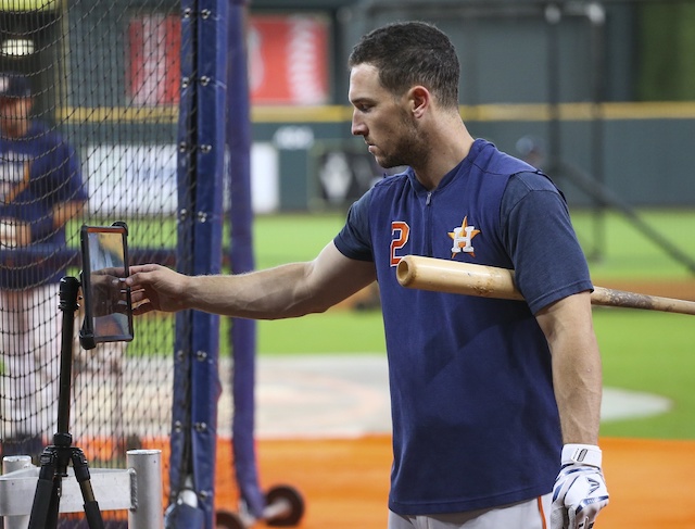 Houston Astros third baseman Alex Bregman looks at his swing on an iPad during batting practice